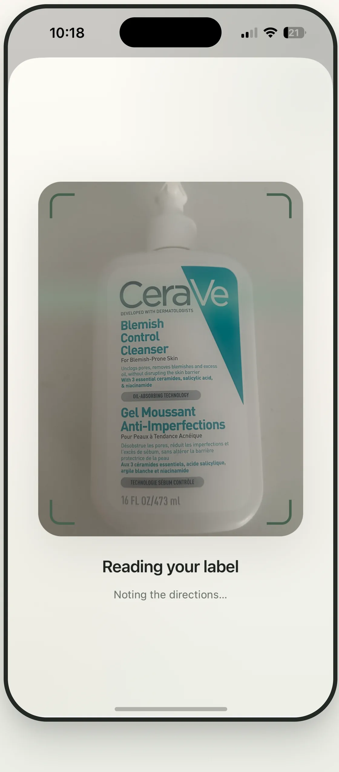 A cleanser bottle inside a viewfinder while Ordava reads the label.